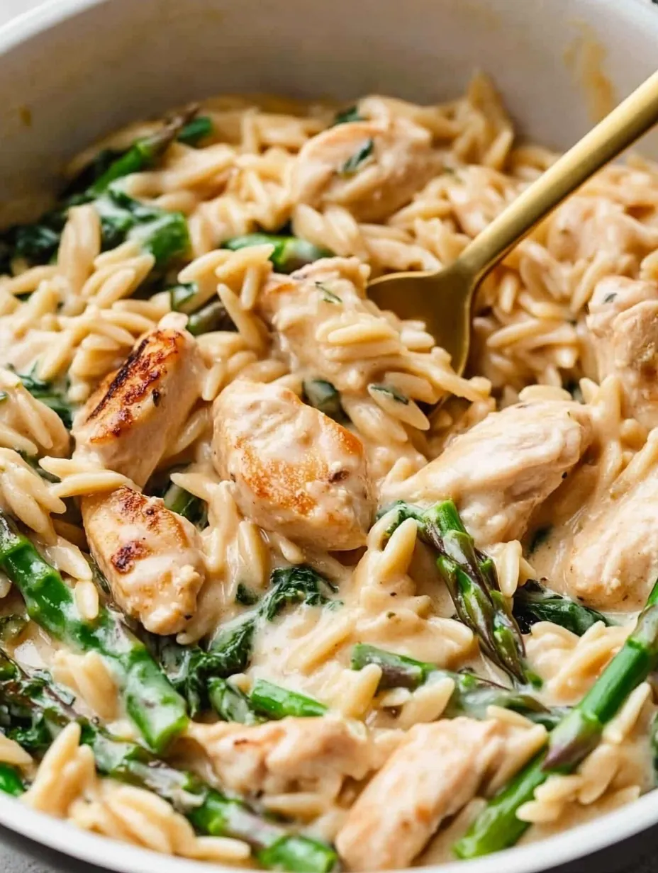 A bowl of pasta with chicken and asparagus.