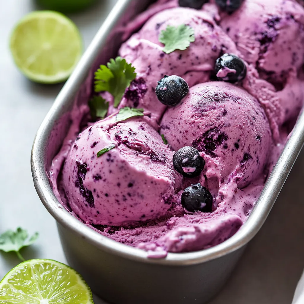 A bowl of yogurt with blueberries and lime.