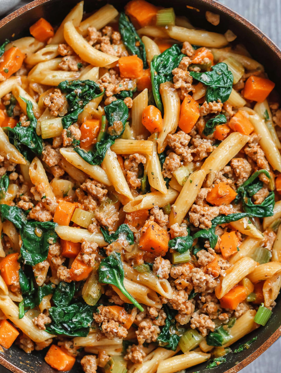 A bowl of pasta with meat and vegetables.