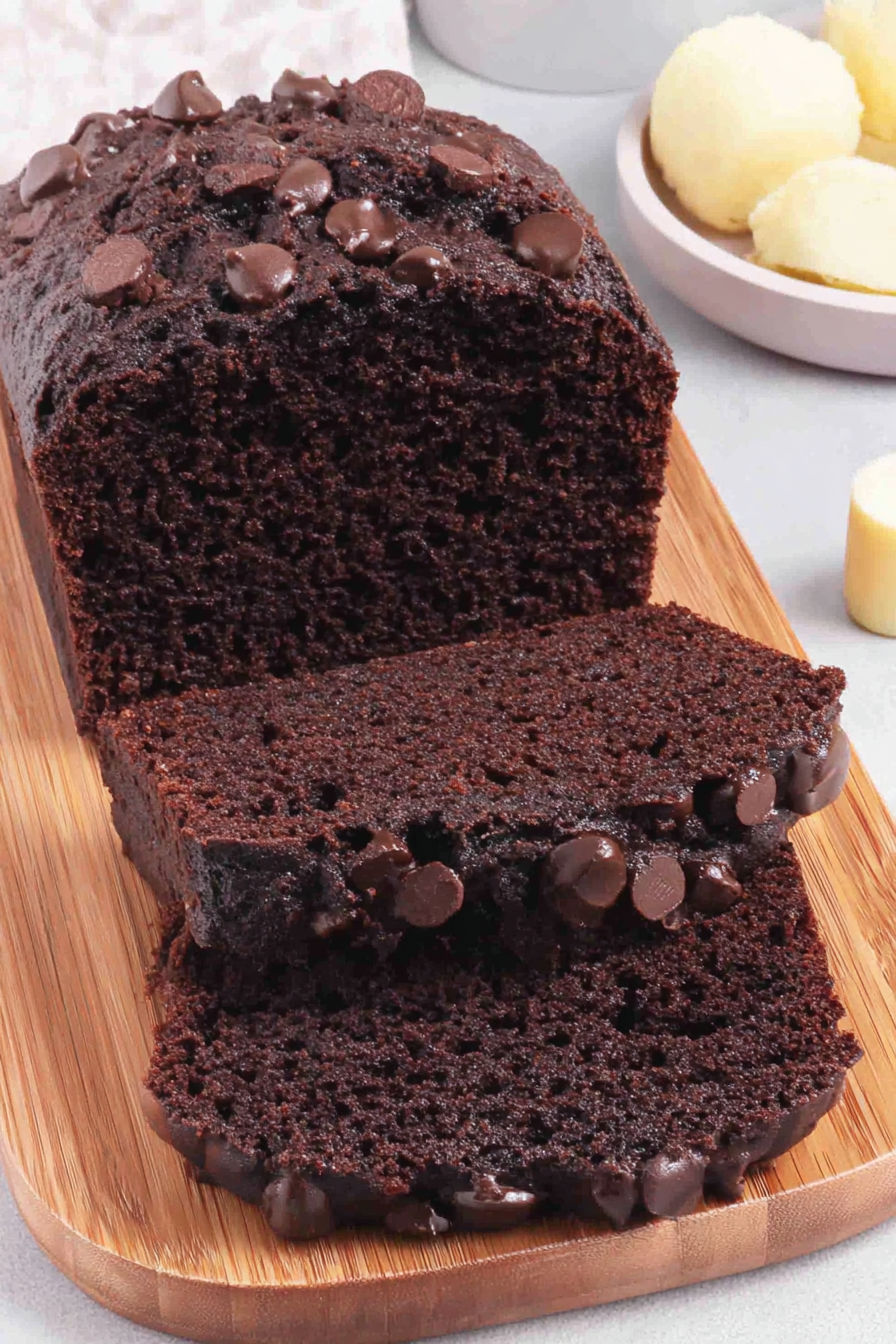 A slice of chocolate cake with chocolate chips.
