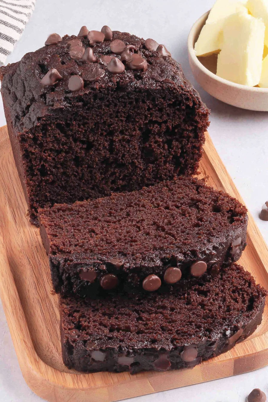 A slice of chocolate cake with chocolate chips.