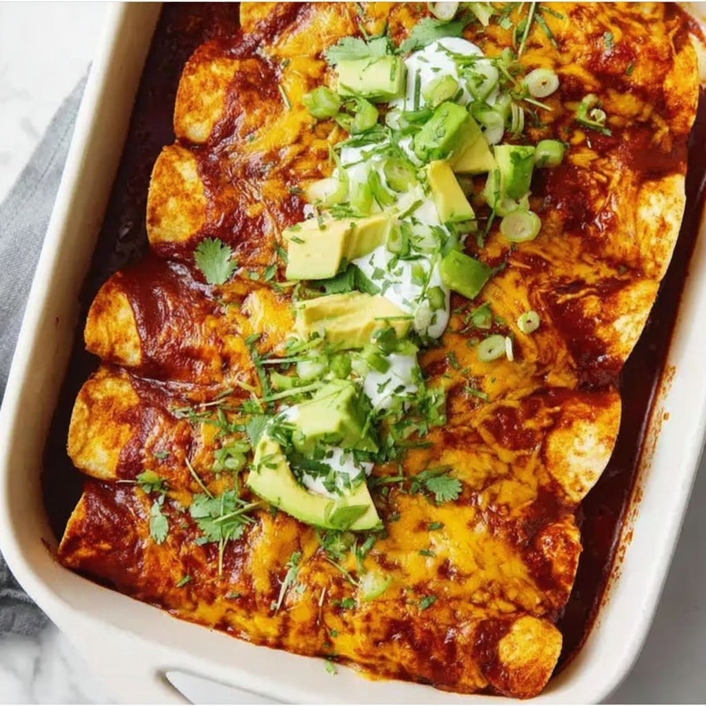 A dish of chicken enchiladas with avocado and cilantro.