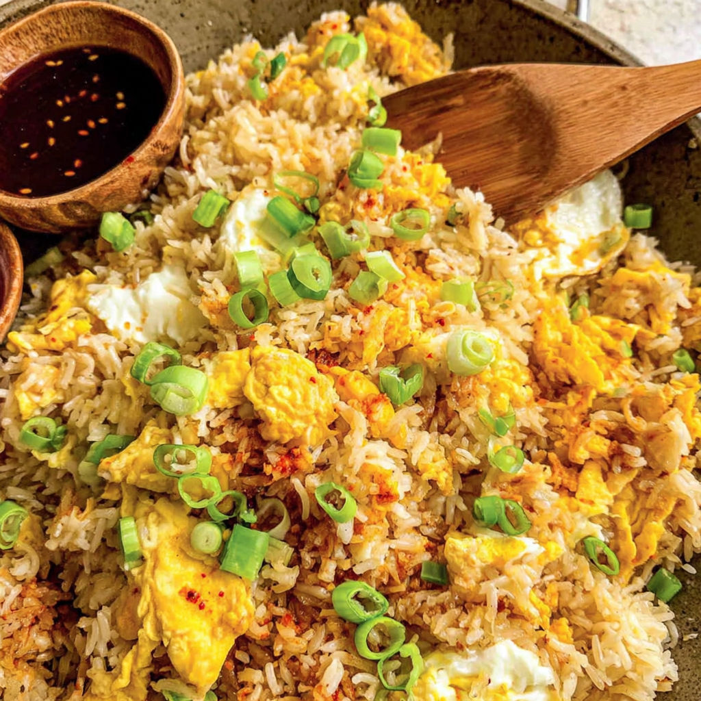 A bowl of rice with eggs and vegetables.