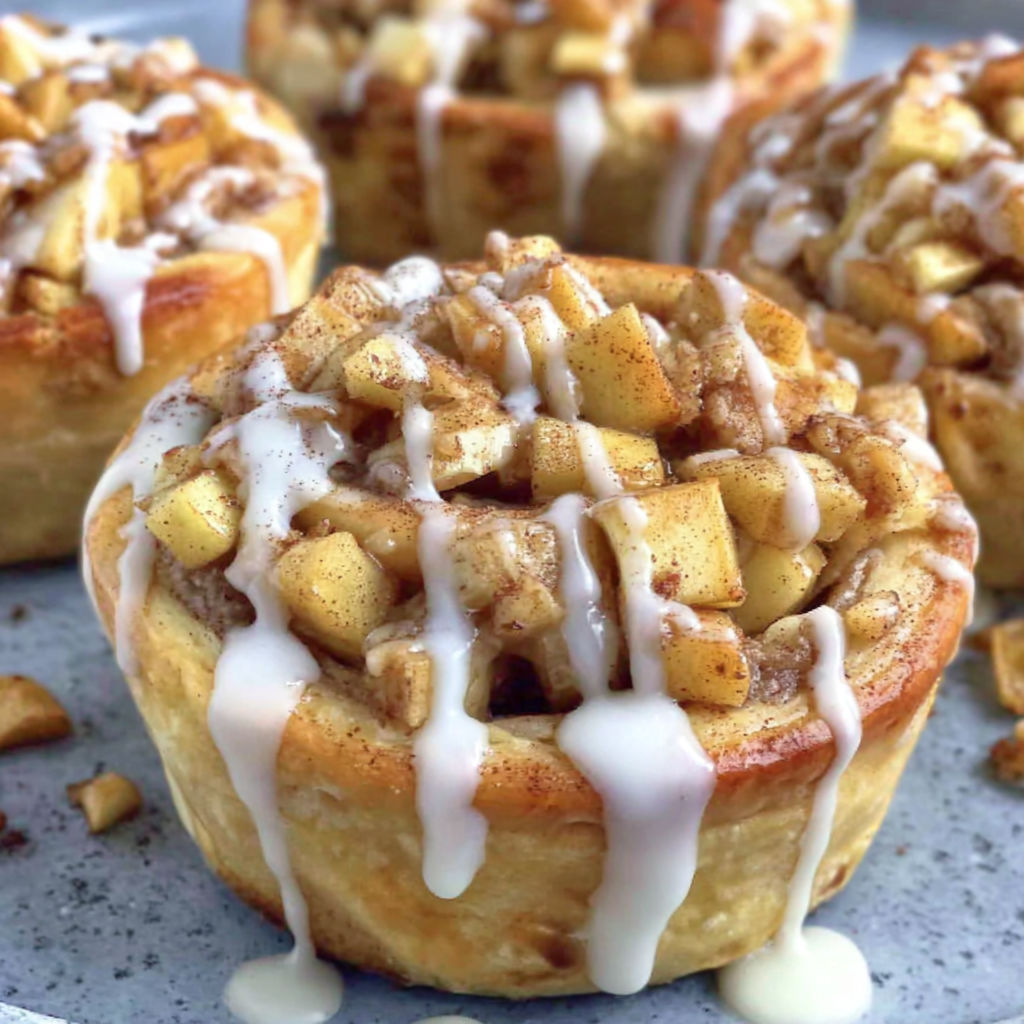 Three apple cinnamon rolls on a plate.