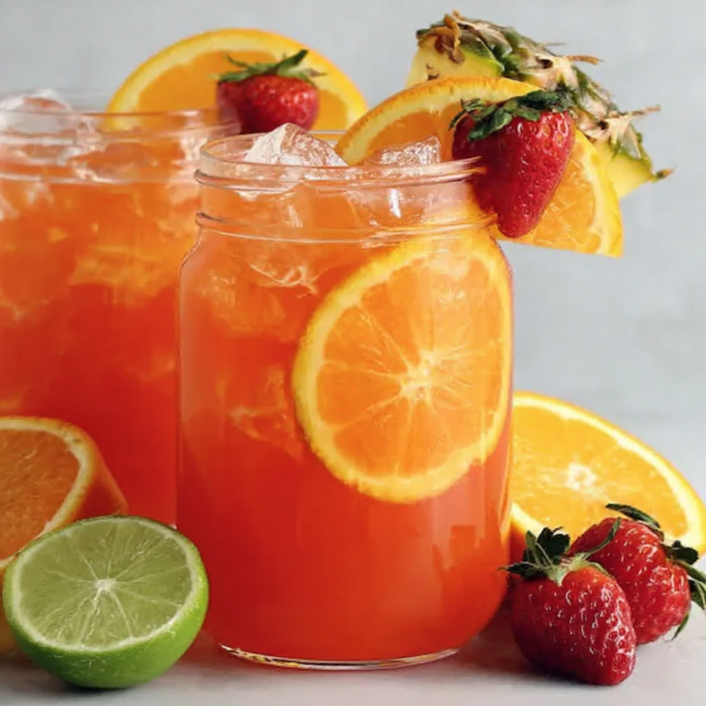 A glass of orange juice with sliced oranges on top.