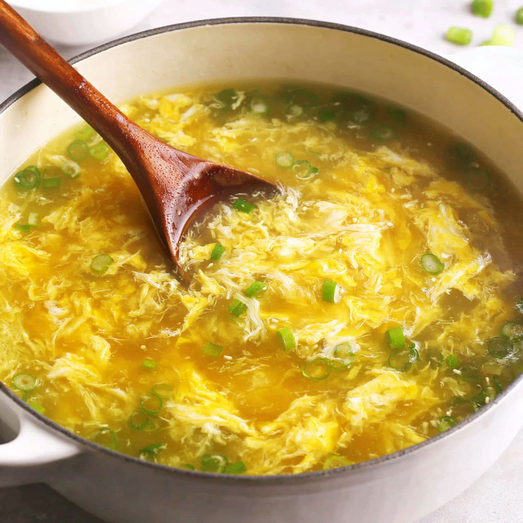 A wooden spoon in a bowl of soup.