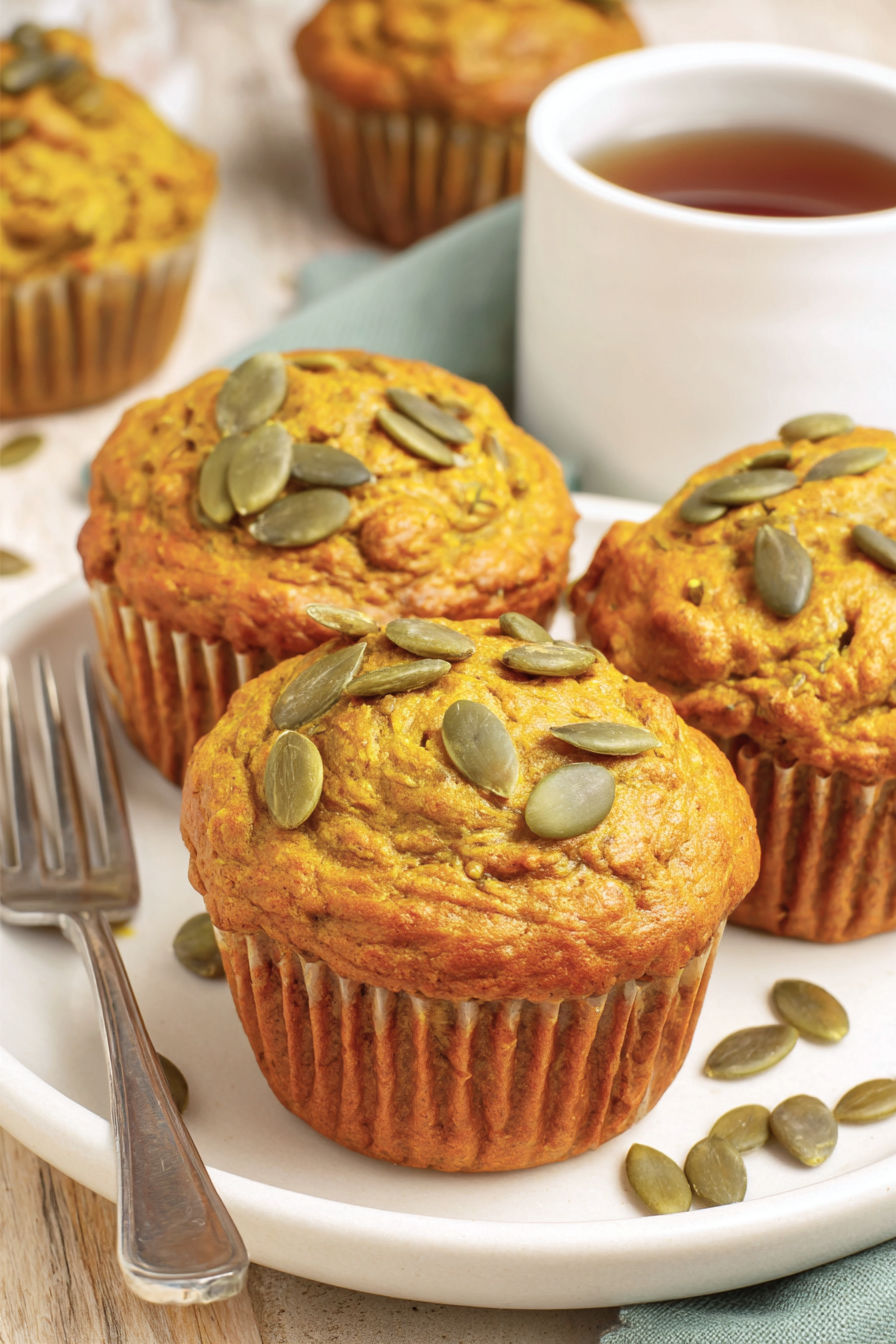 Three muffins with seeds on top.