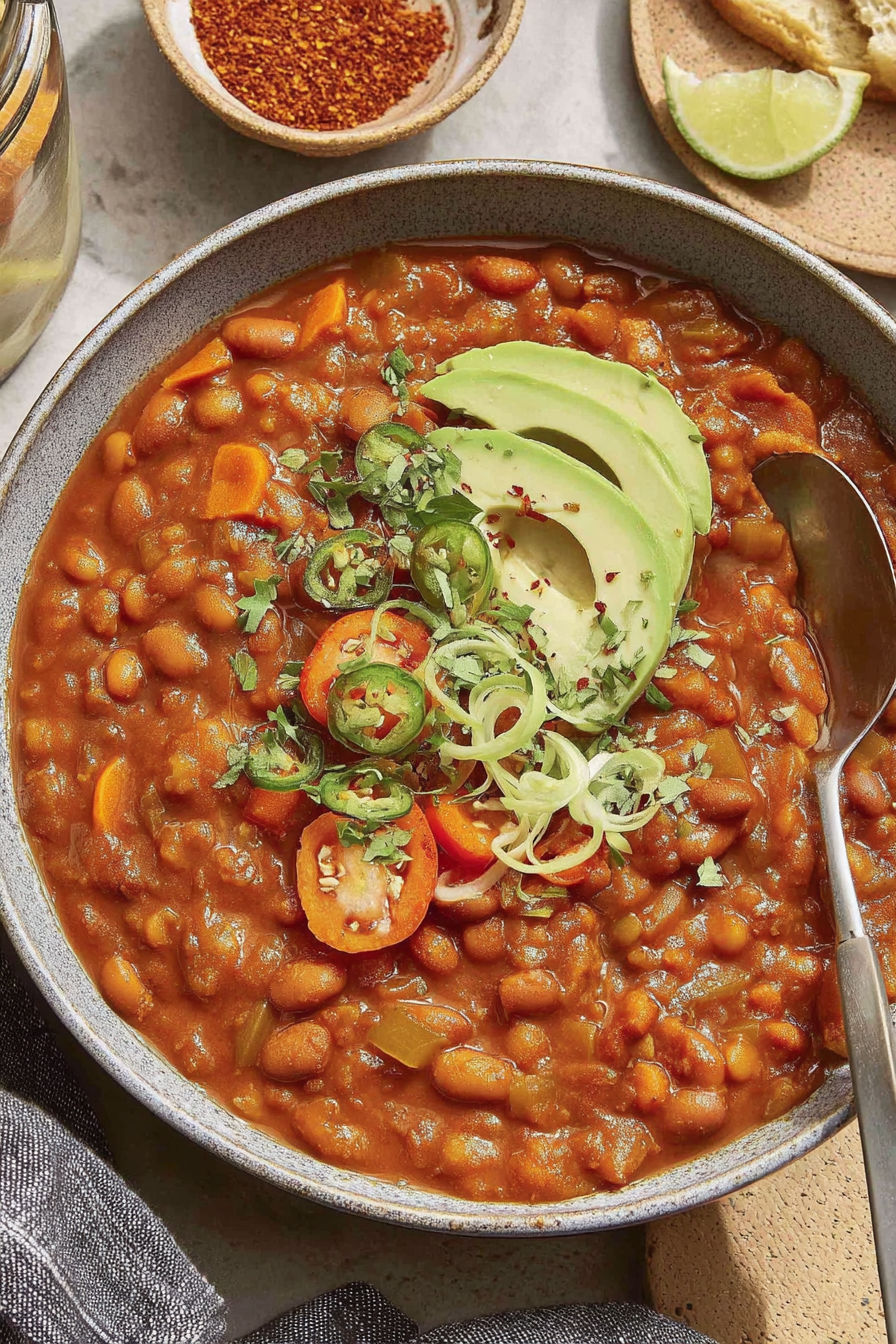A bowl of chili with a spoon in it.