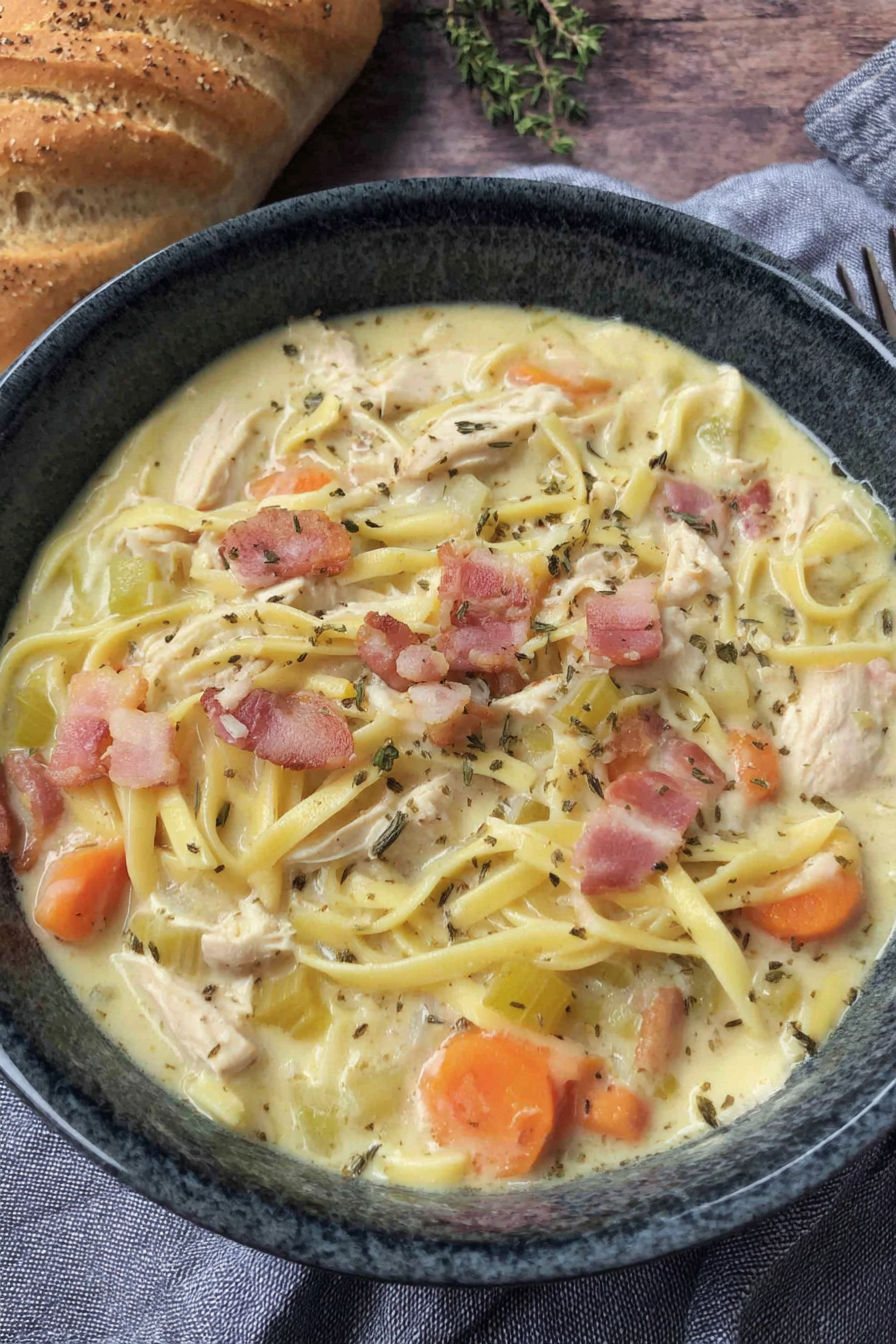 A bowl of soup with chicken and noodles.