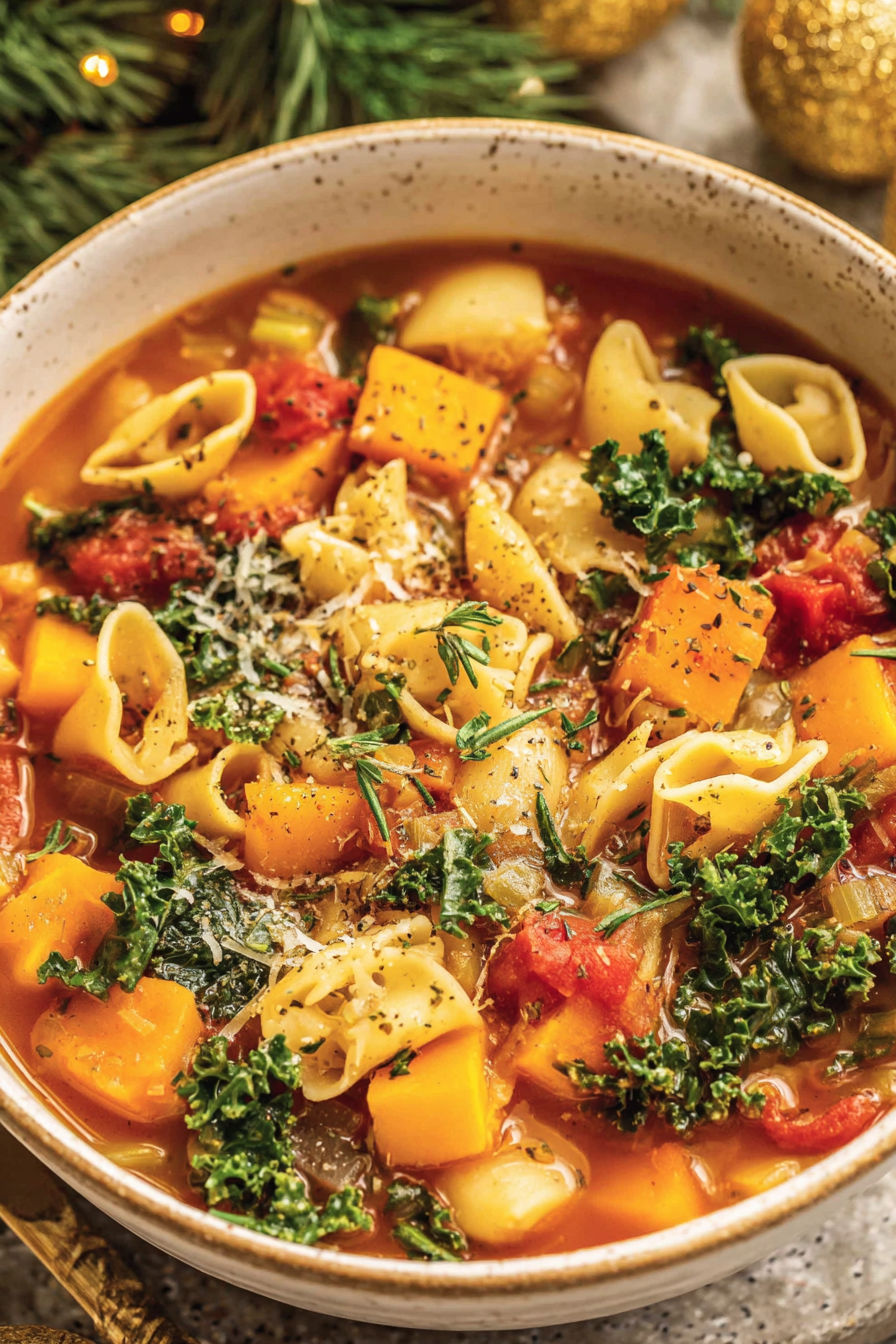 A bowl of soup with butternut squash and kale.