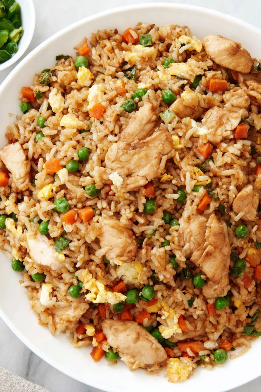 A bowl of rice with chicken and peas.