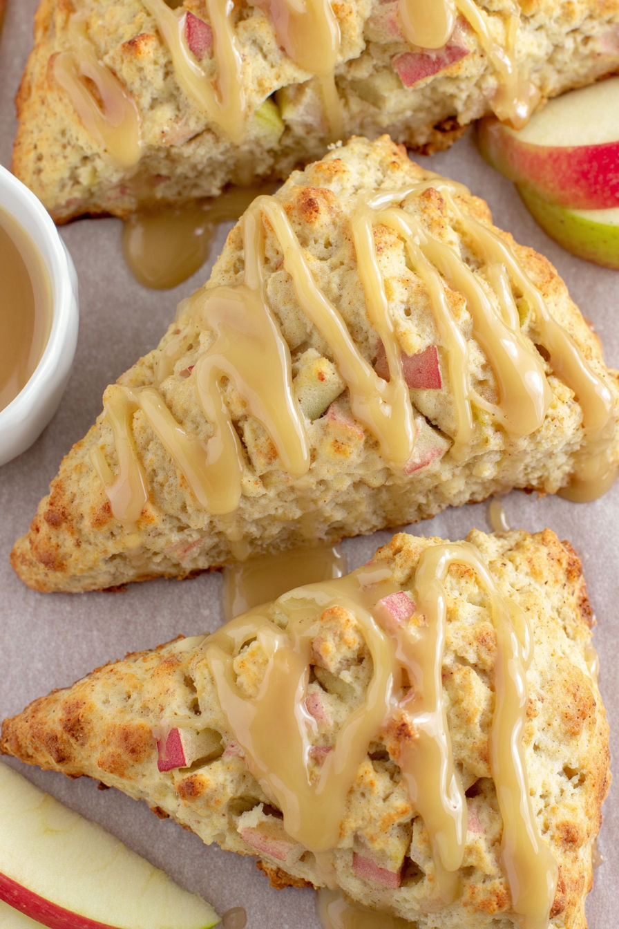 A close up of a moist apple scone with maple glaze.