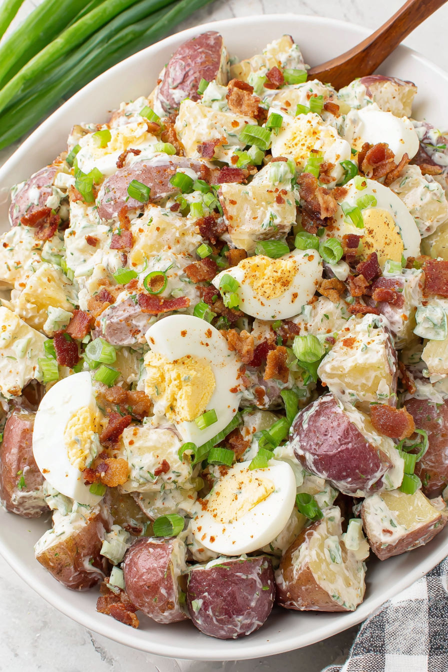 A dish of roasted potato salad with bacon and eggs.