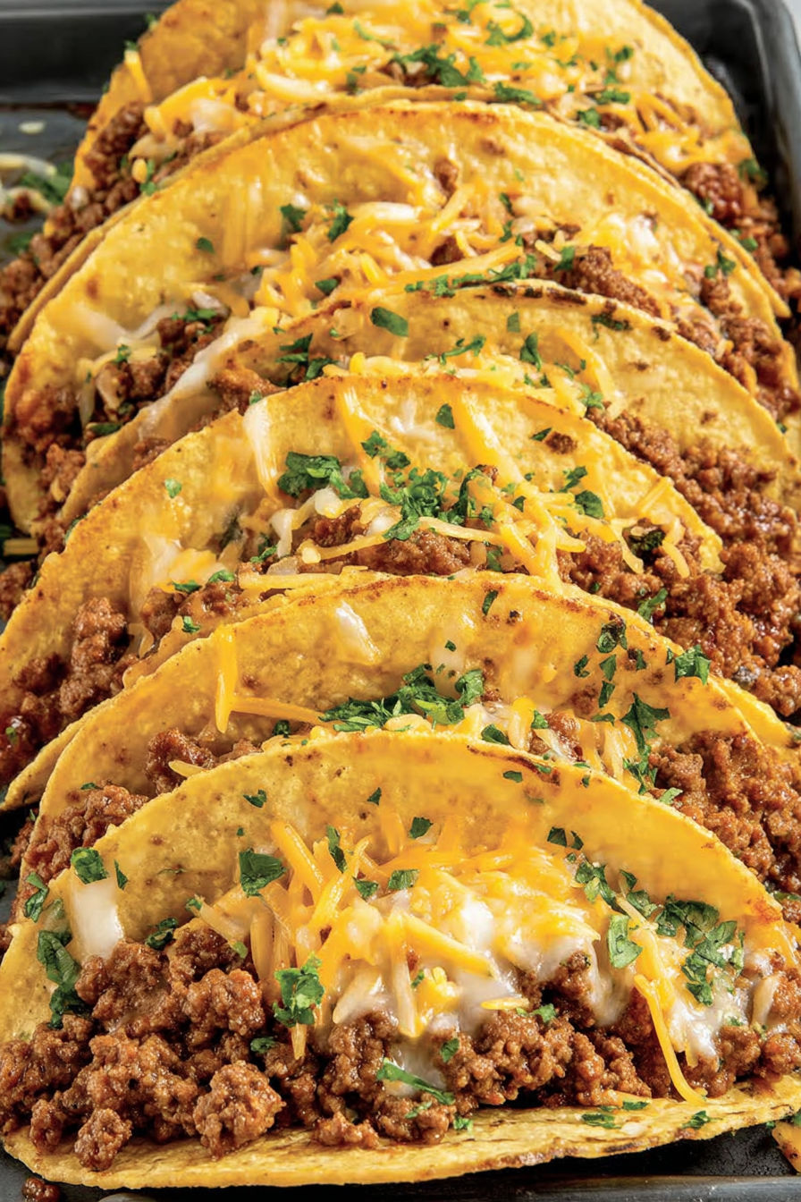 A plate of baked tacos with cheese and meat.