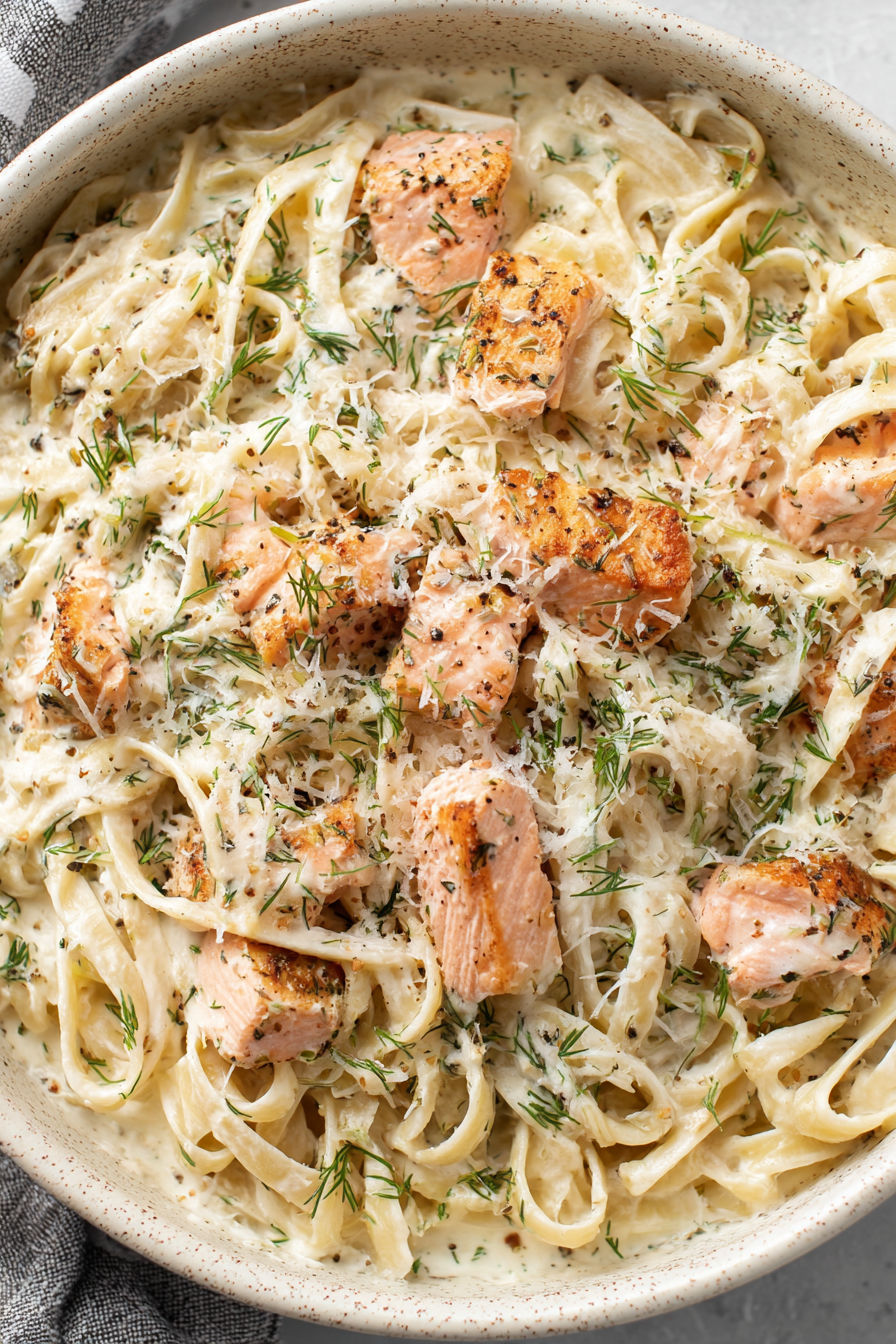 A bowl of pasta with salmon and dill.