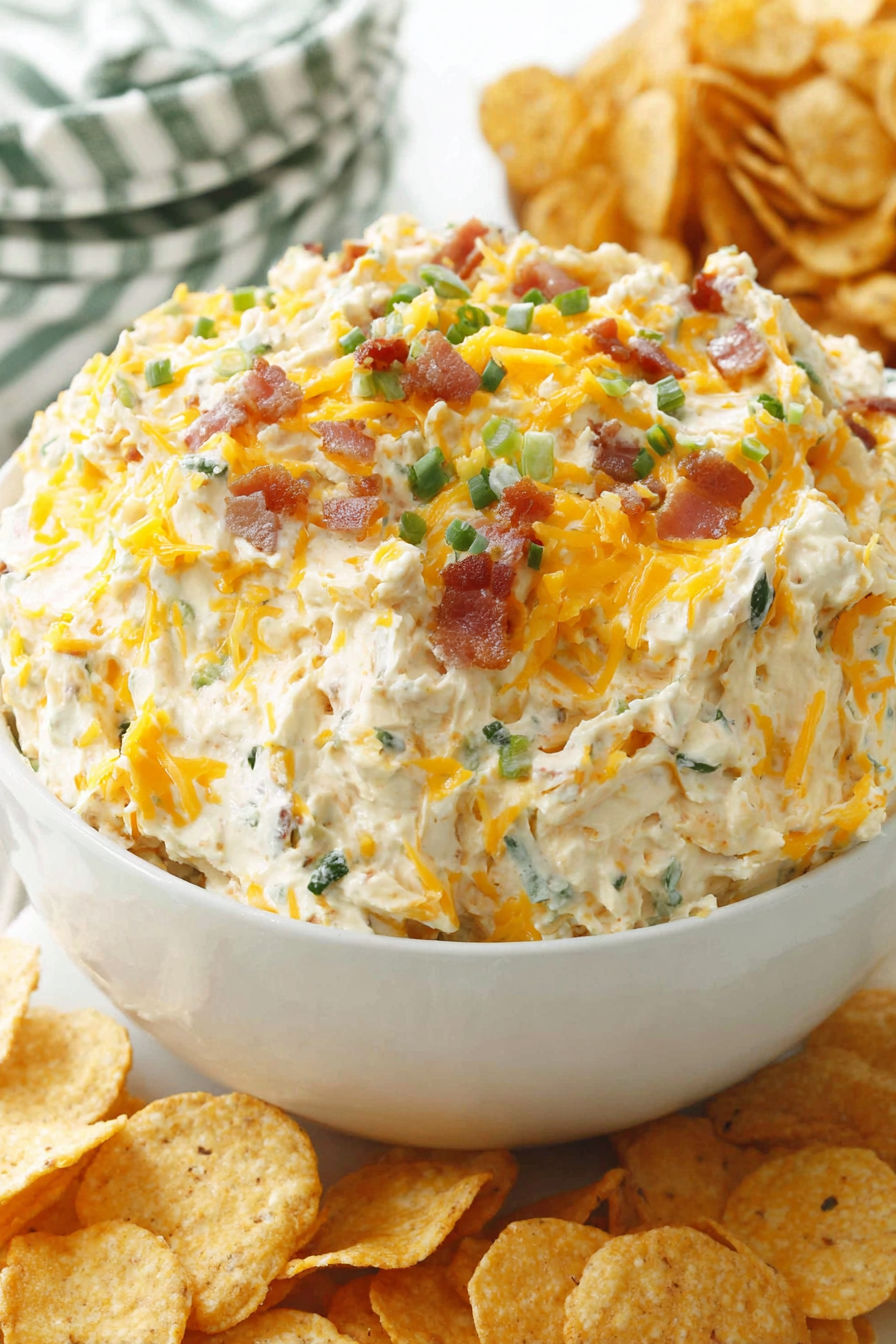 A white bowl filled with a baked potato dip.