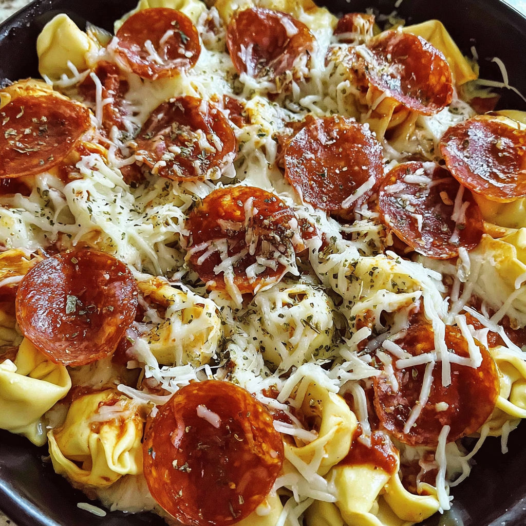 A dish of pasta with pepperoni and cheese.