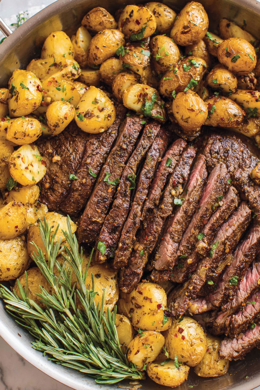 A delicious meal of steak, potatoes, and herbs.
