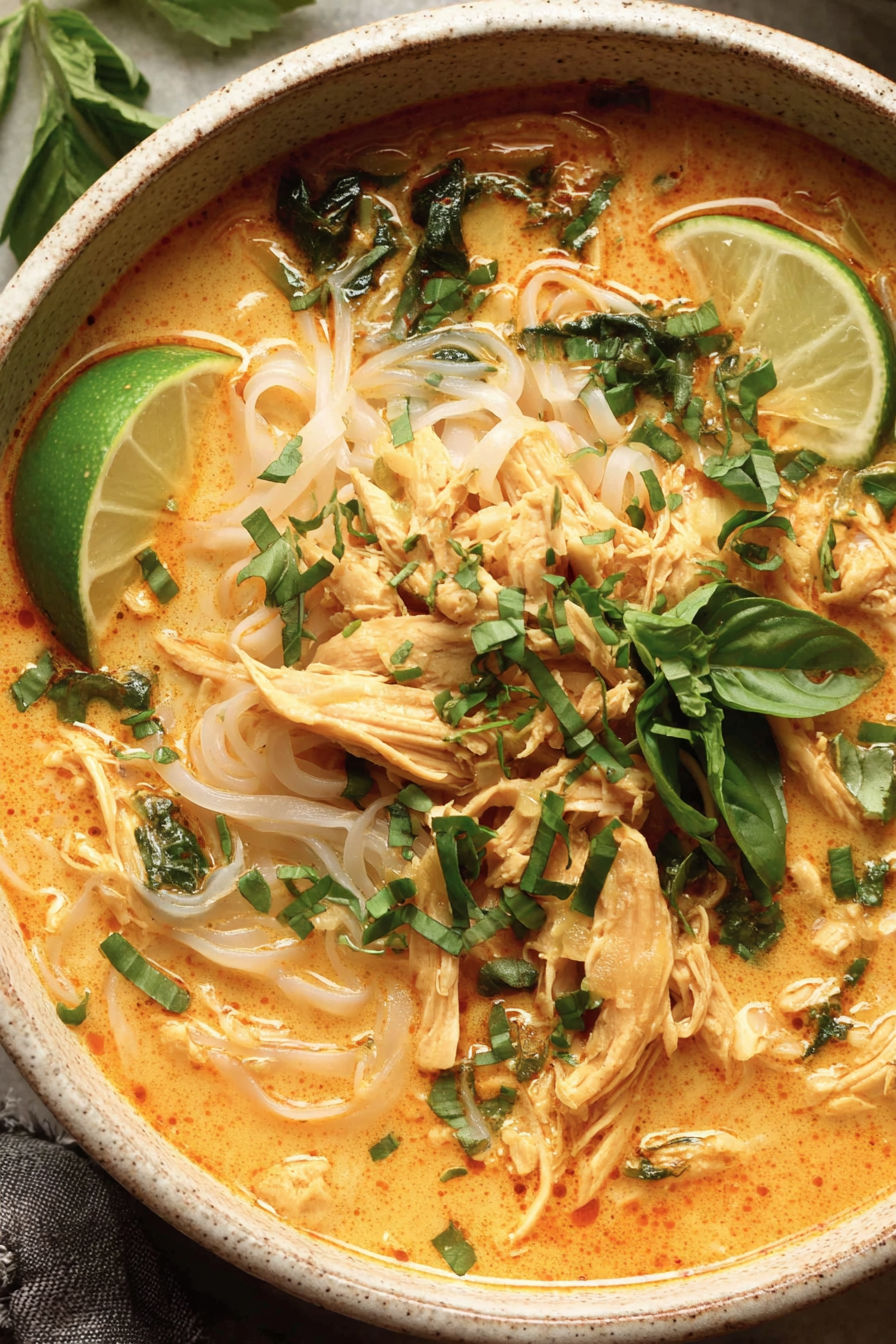 A bowl of soup with chicken and lime.