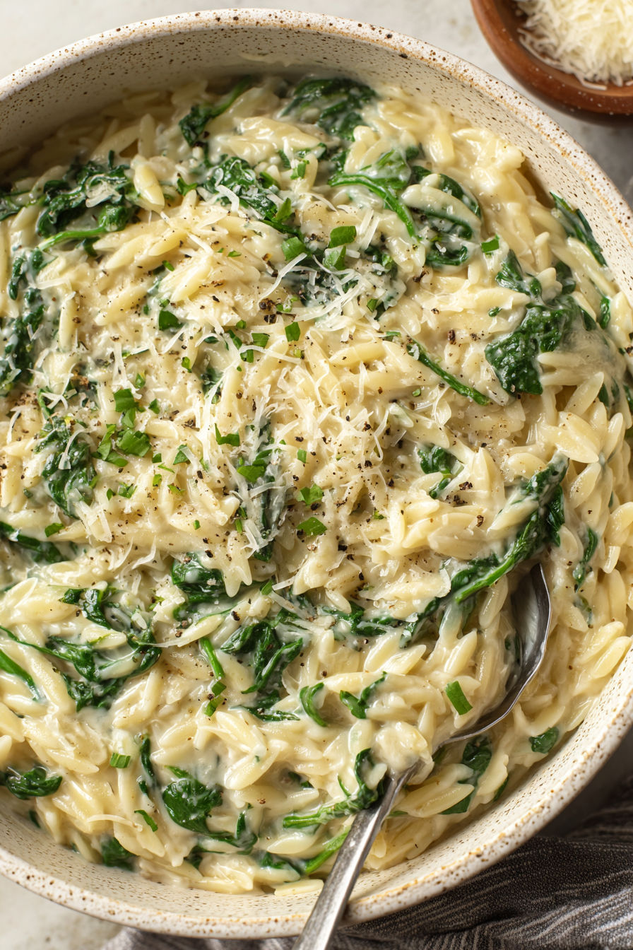 A bowl of creamy garlic spinach orzo.
