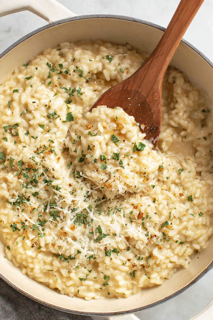 A wooden spoon is in a bowl of rice.