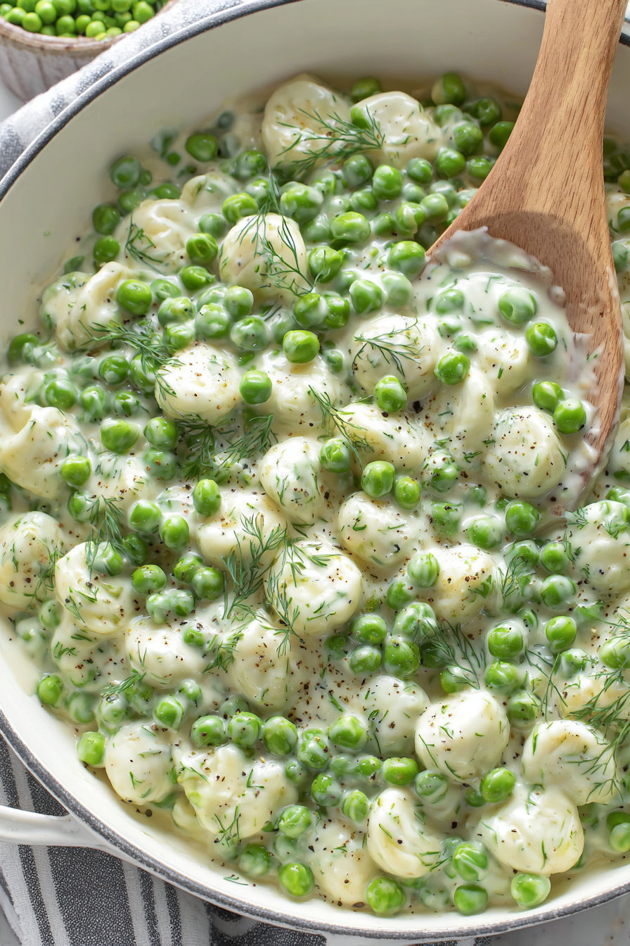 A bowl of food with peas and cheese.