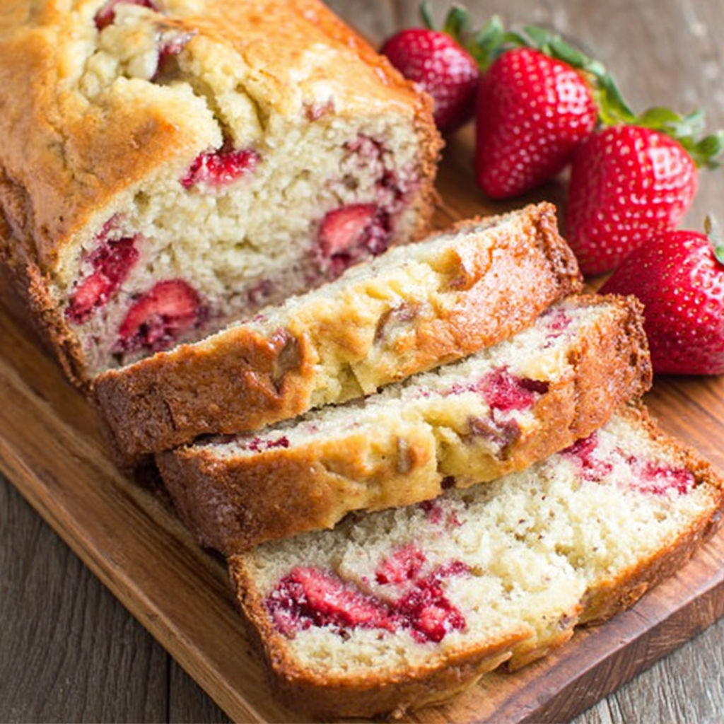 A slice of banana bread with strawberries on top.