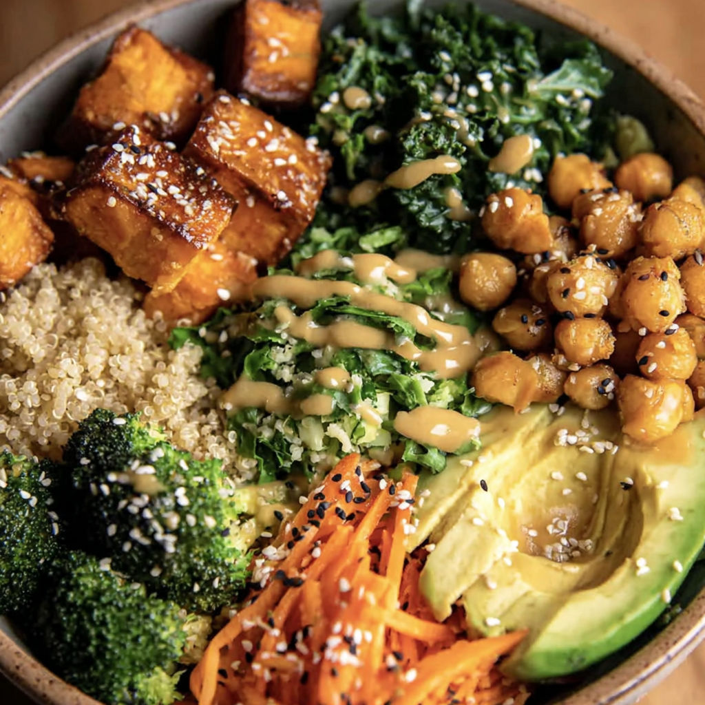 A bowl of vegetables including sweet potatoes, broccoli, and carrots.