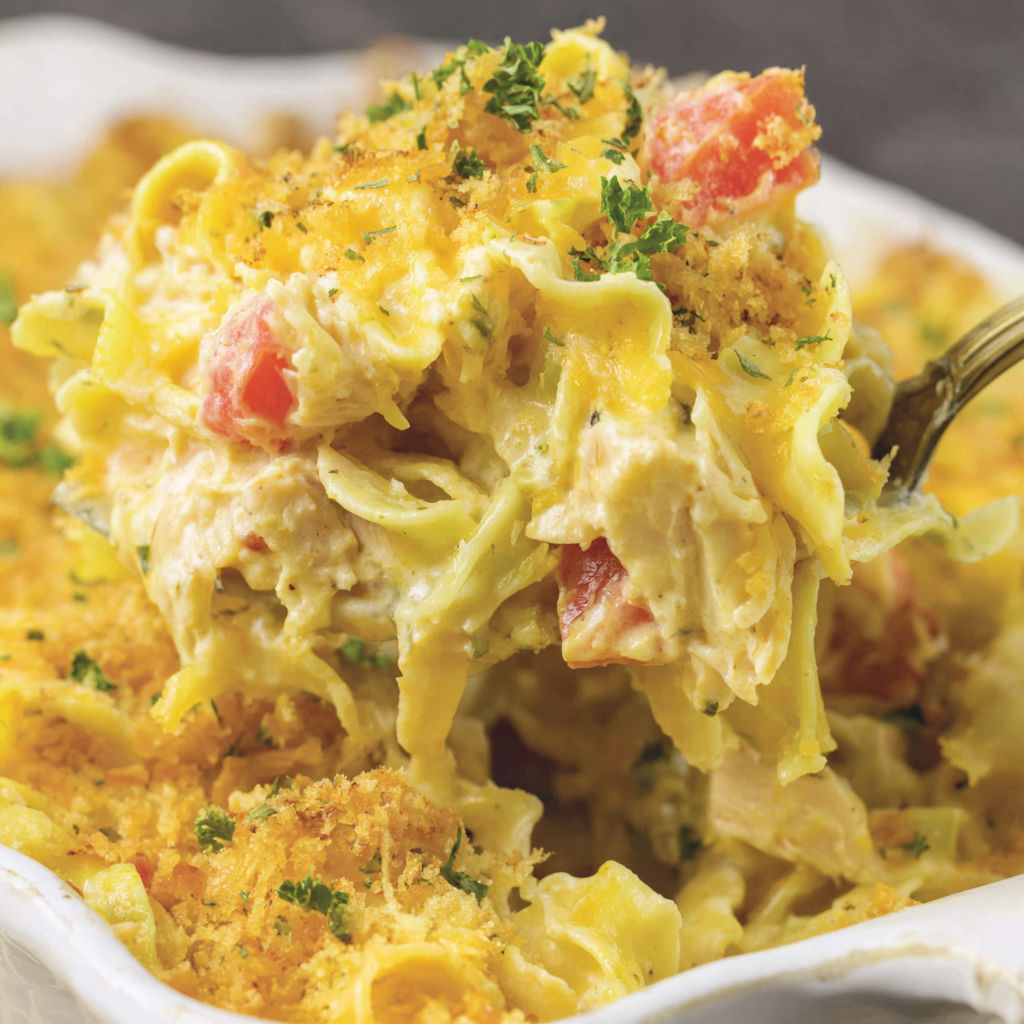 A plate of chicken casserole with tomatoes and herbs.
