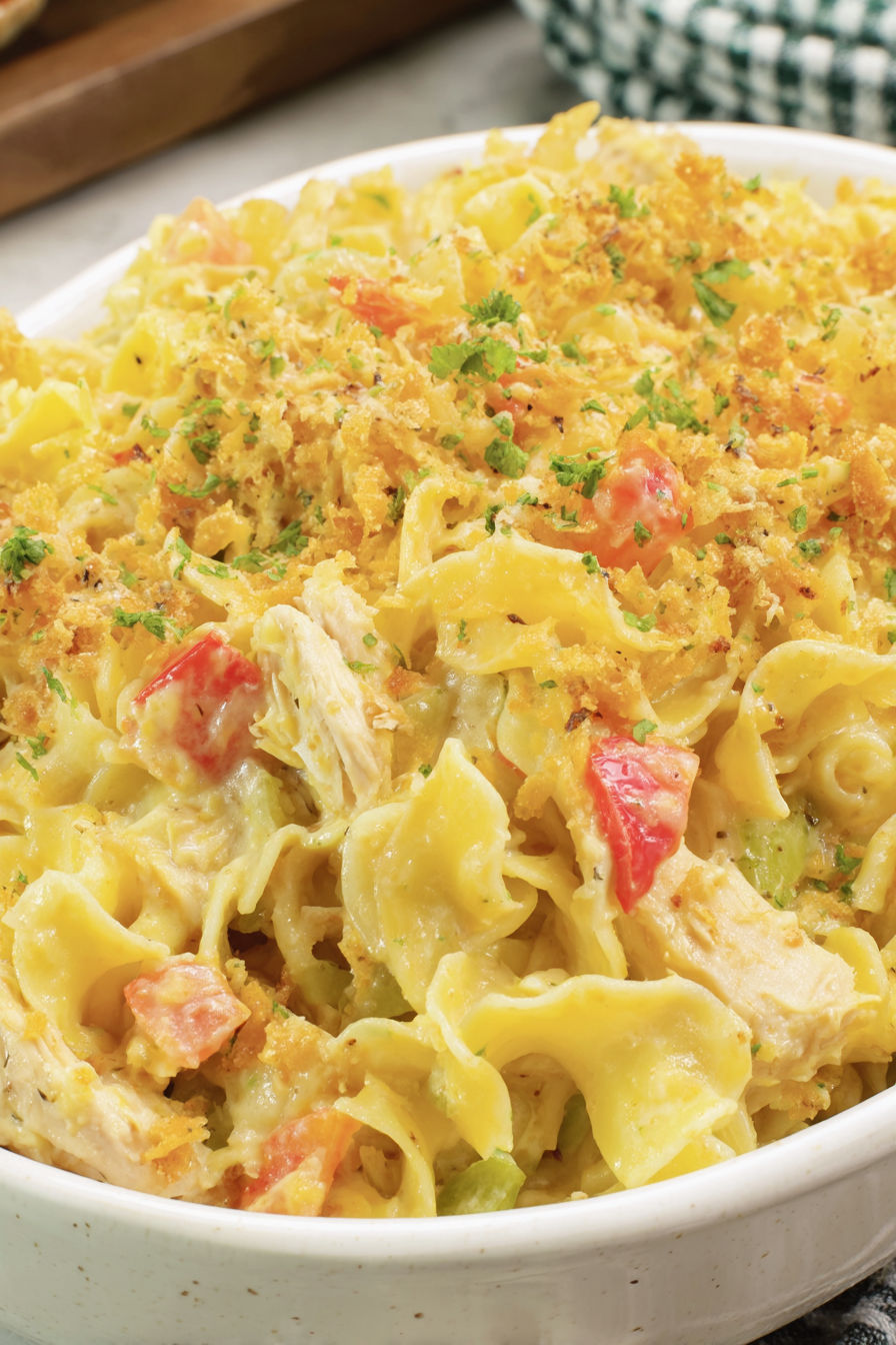 A close up of a chicken casserole with noodles and vegetables.