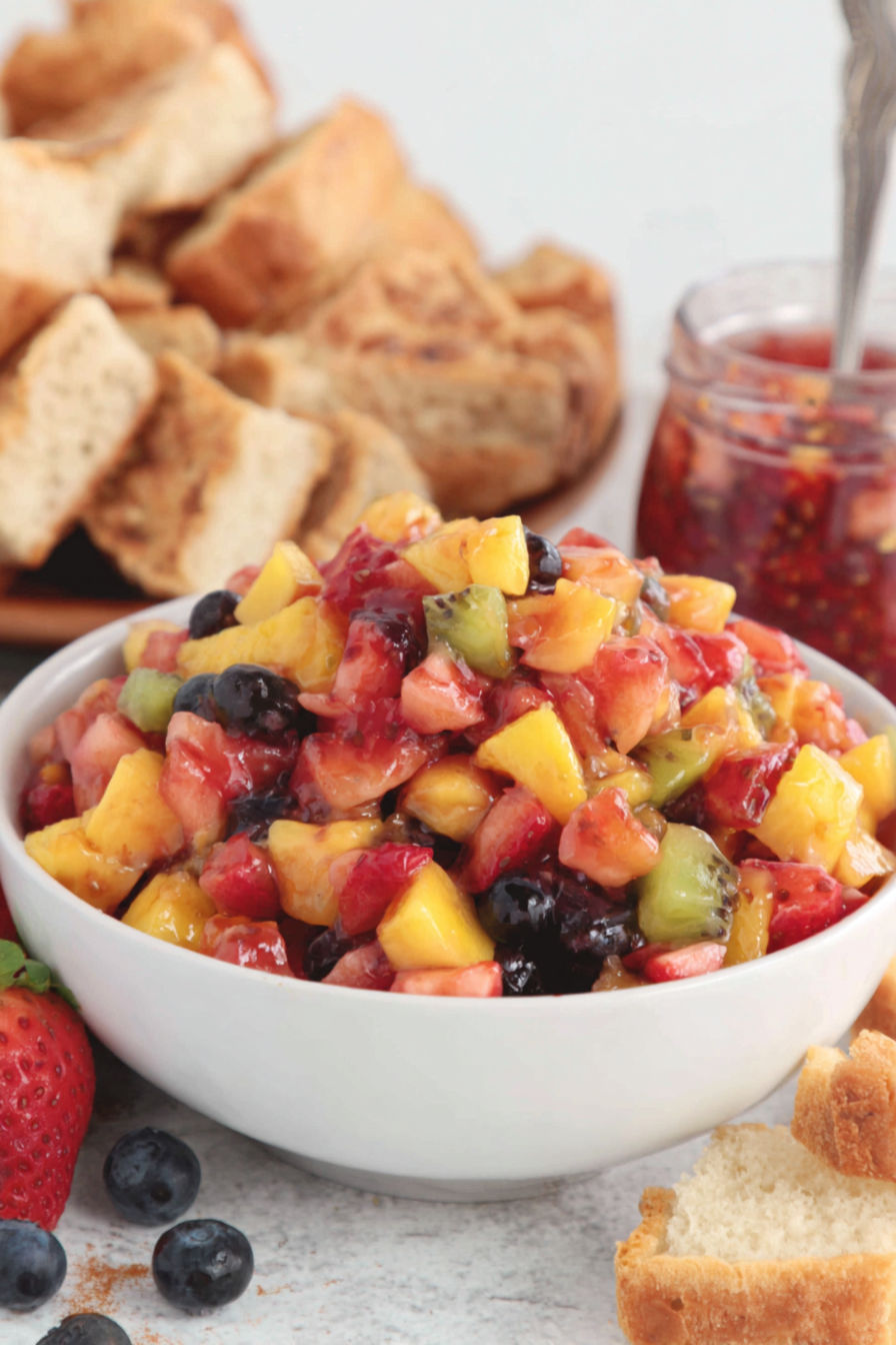 A bowl of fruit salsa with cinnamon chips.