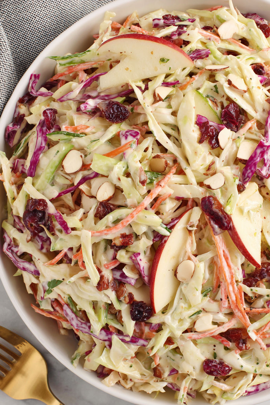 A bowl of apple slaw with chopped apples and nuts.