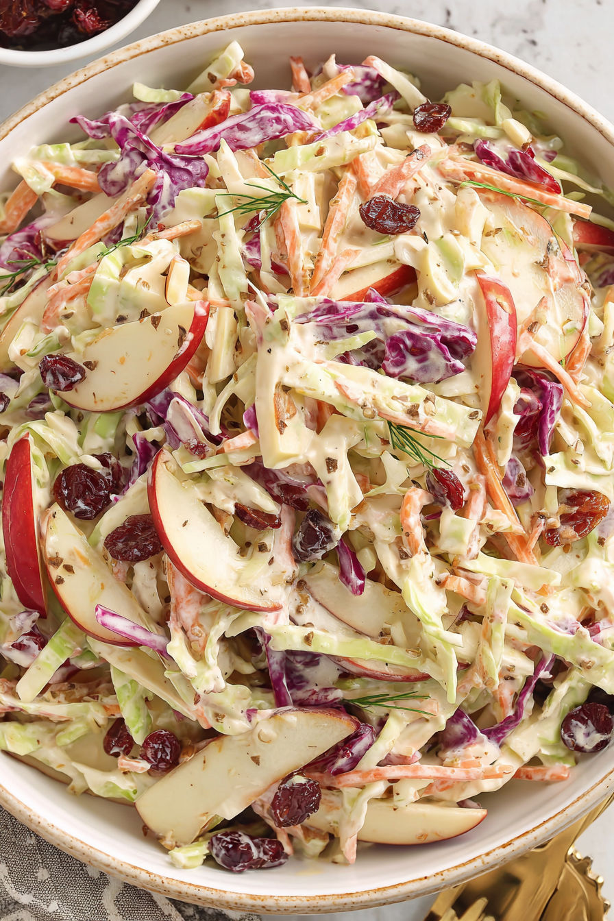 A bowl of apple slaw with various fruits and vegetables.