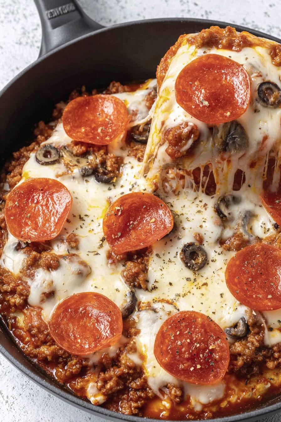 A bowl of crustless pizza with cheese and olives.