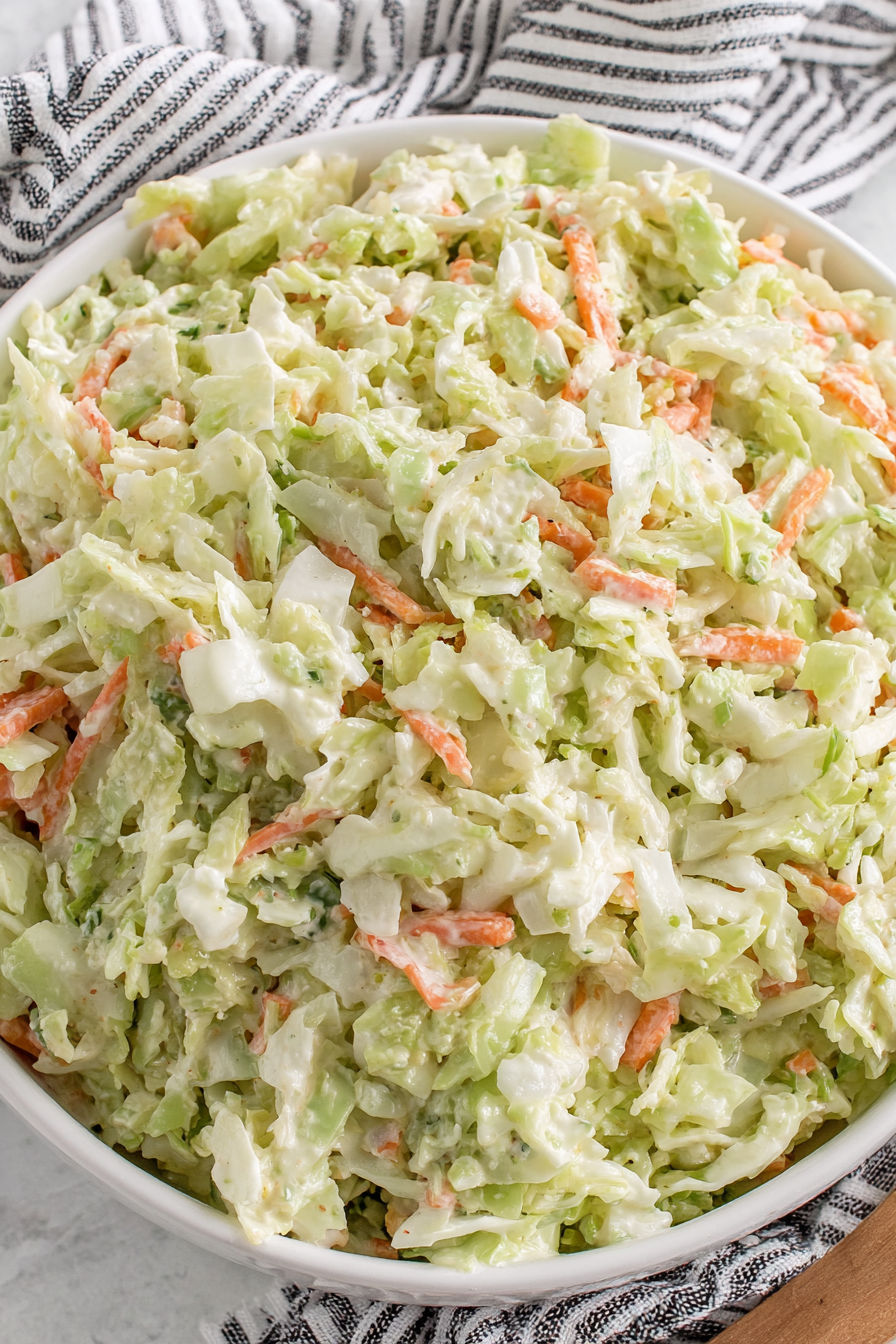 A large bowl of coleslaw with carrots and cabbage.
