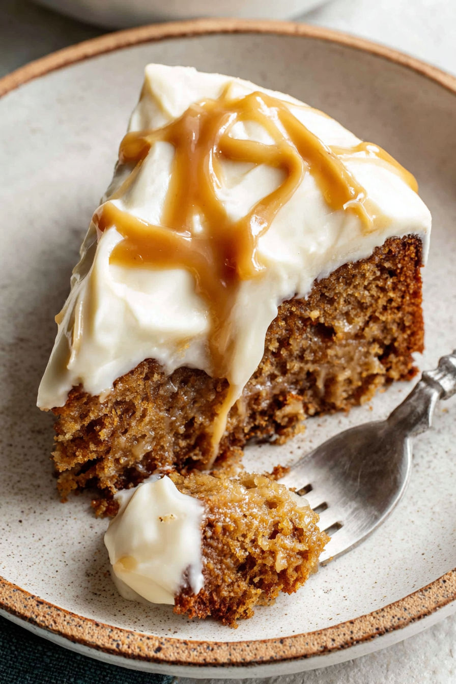 A slice of apple spice cake with salted caramel cream cheese frosting.