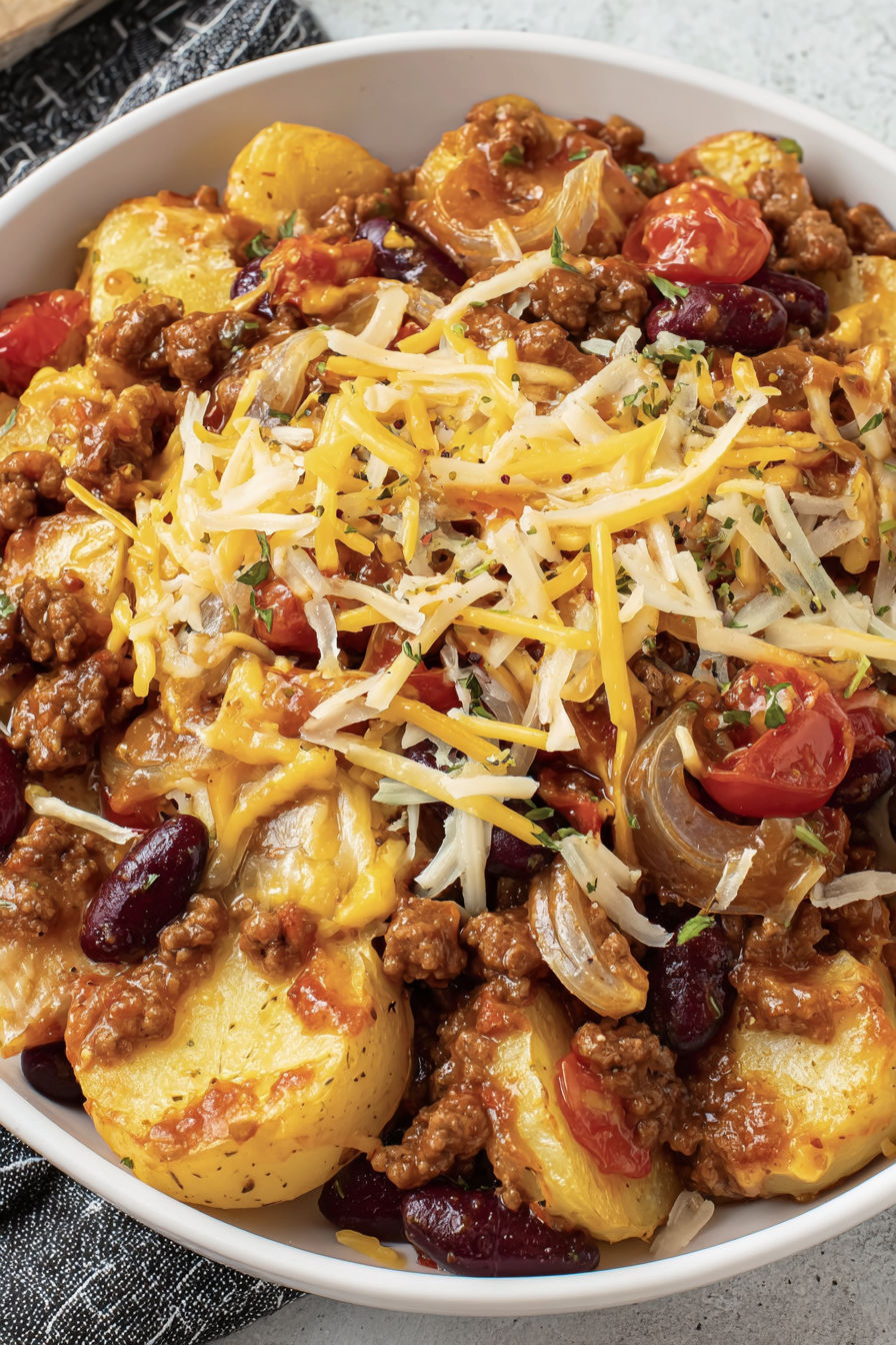 A bowl of food with cheese and tomatoes.