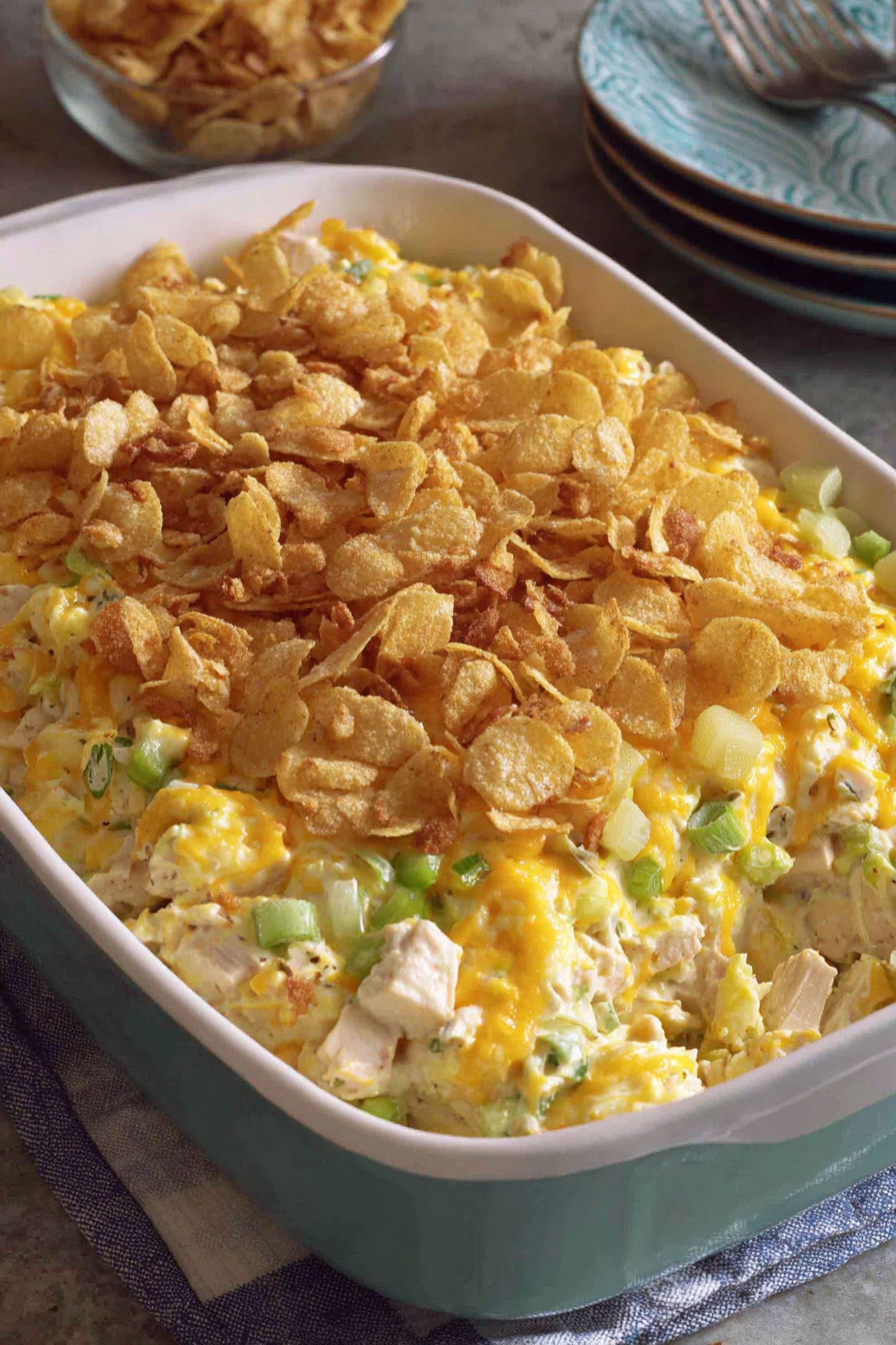 A dish of chicken salad with chips on top.