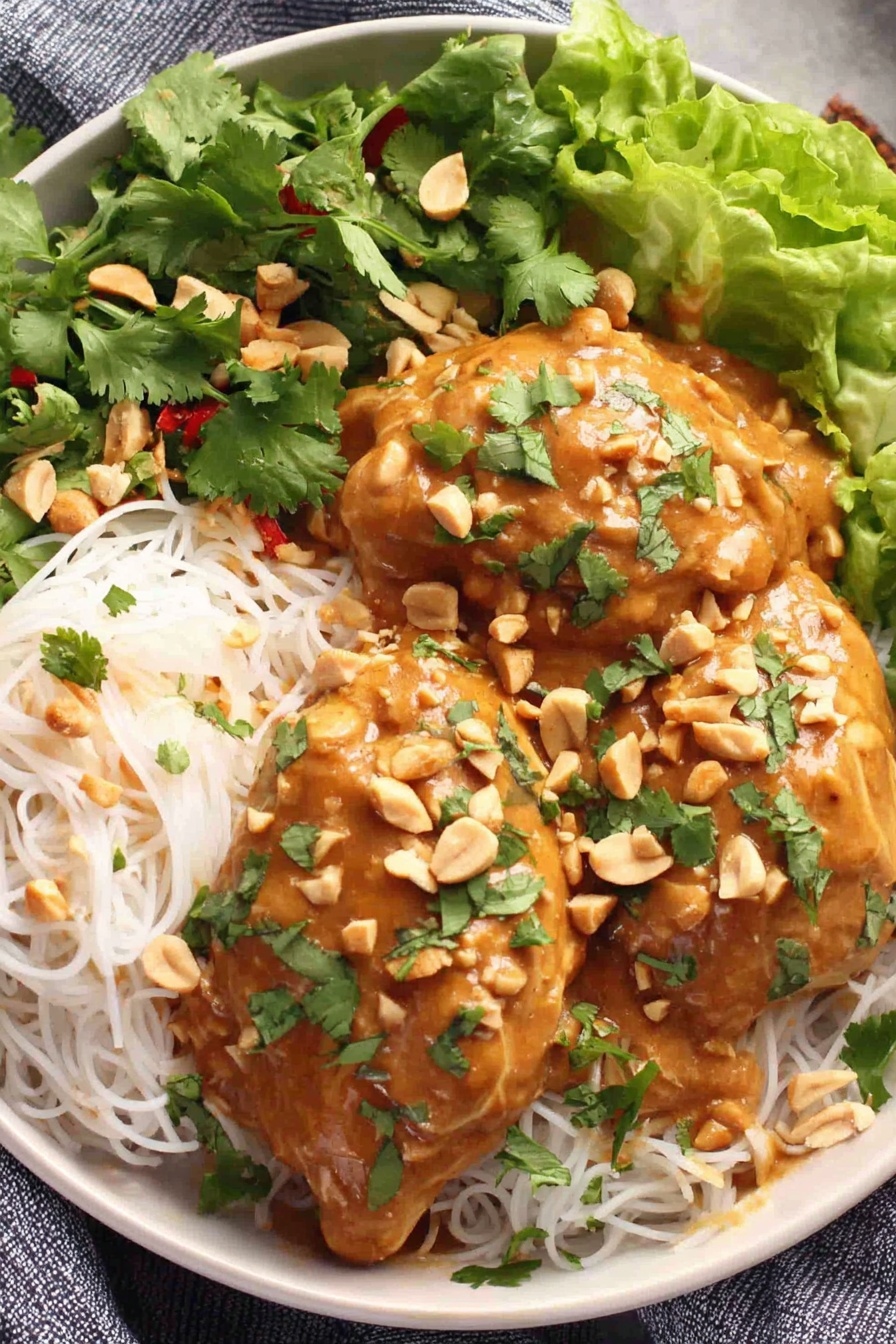 A plate of food with peanut sauce and chicken.