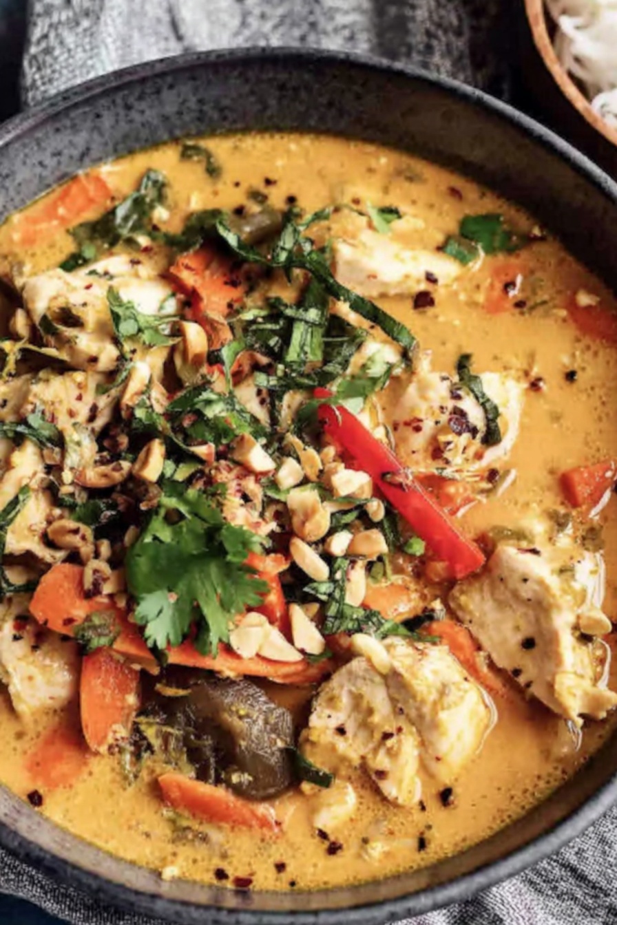 A bowl of soup with chicken and vegetables.