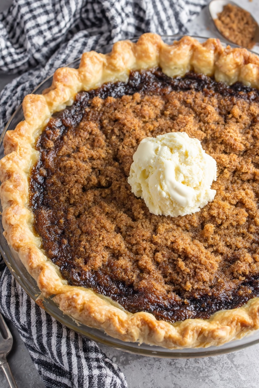 A slice of Shoofly Pie with a scoop of ice cream on top.