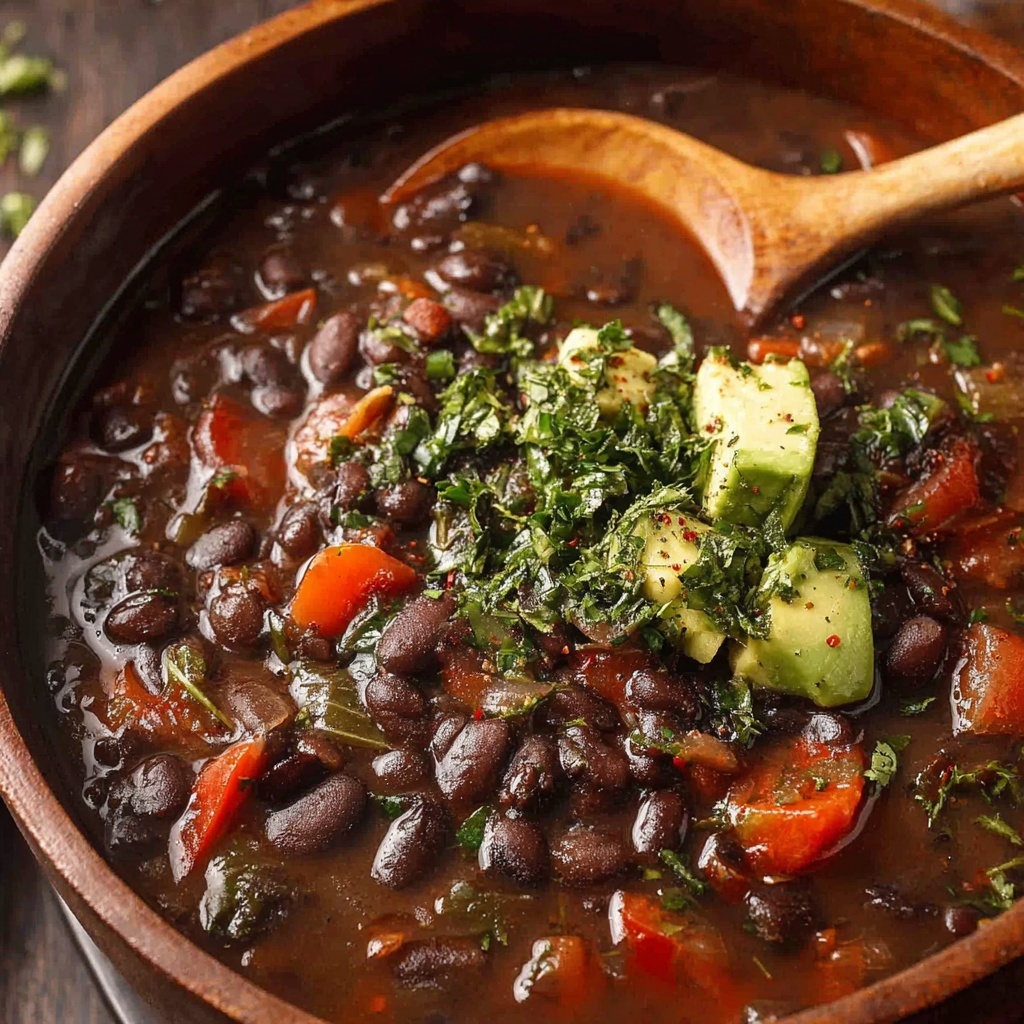 A bowl of spicy black bean soup with a spoon in it.