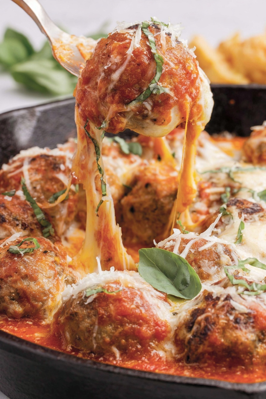 A close up of a meatball parmesan dish.