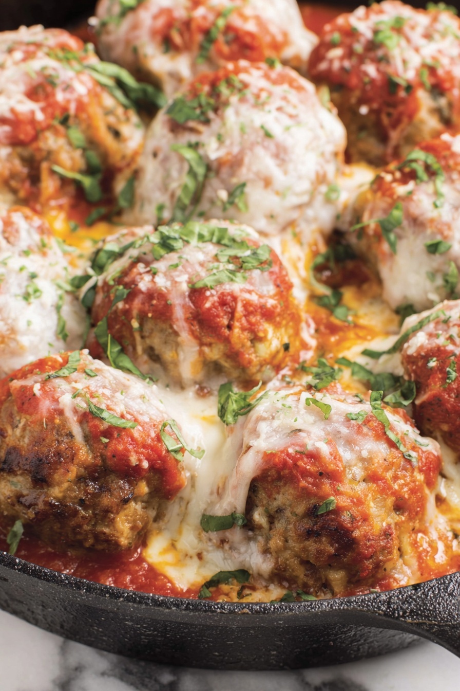 A pan of meatballs covered in cheese.