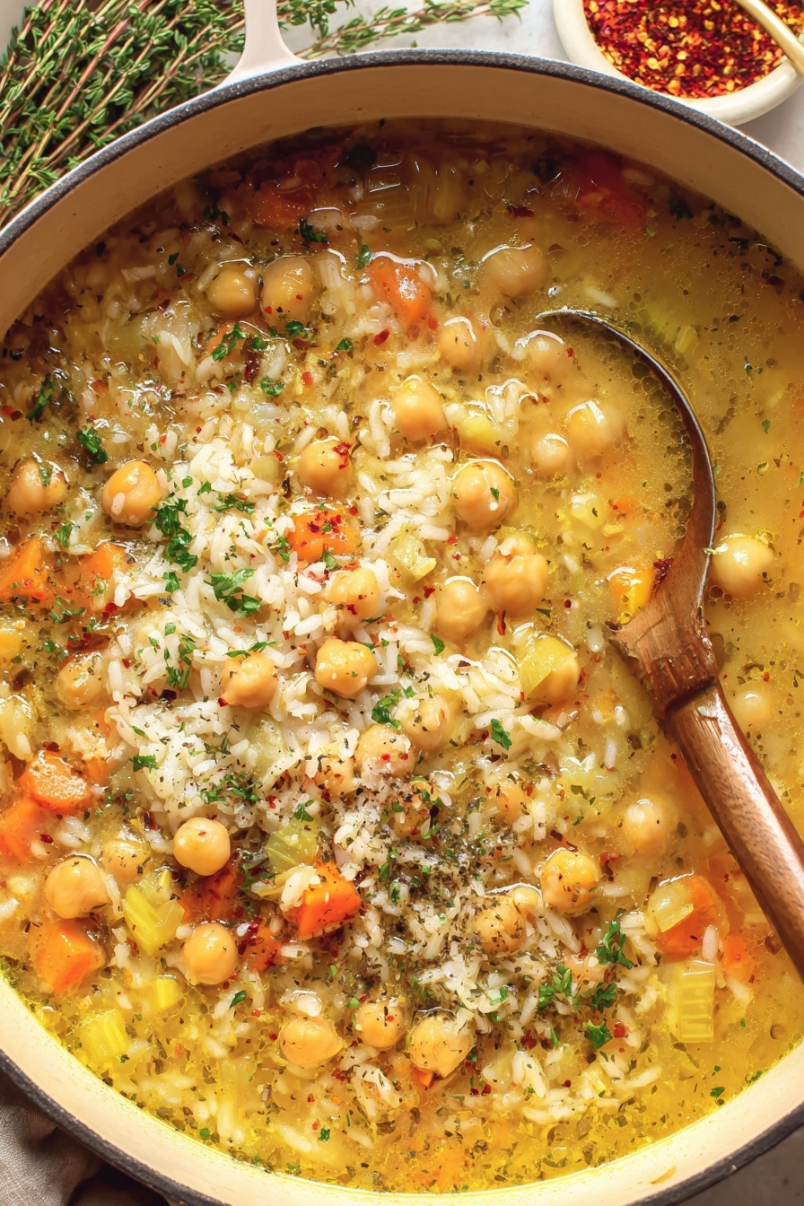 A bowl of soup with rice, chickpeas, and carrots.