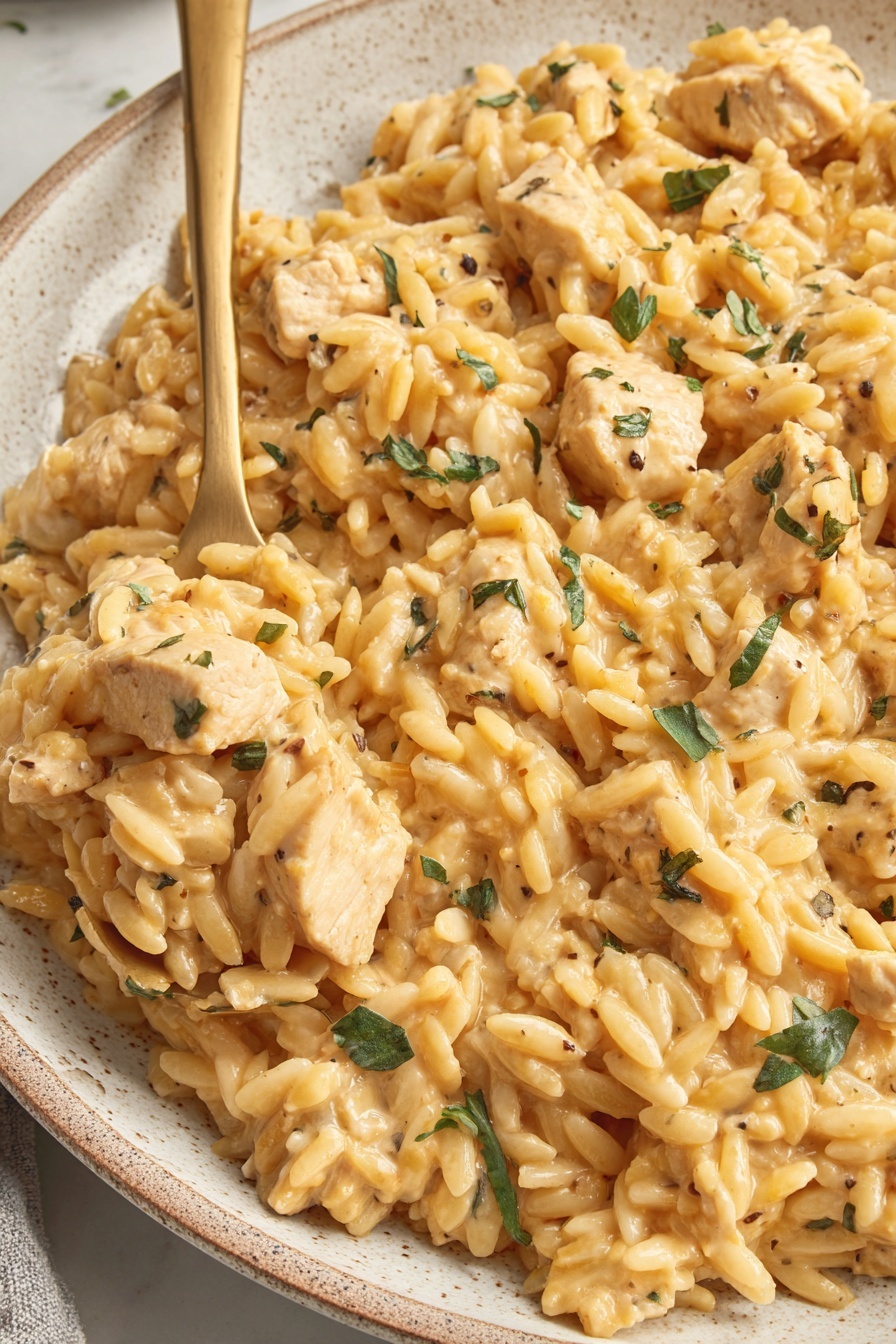 A bowl of rice with chicken and herbs.