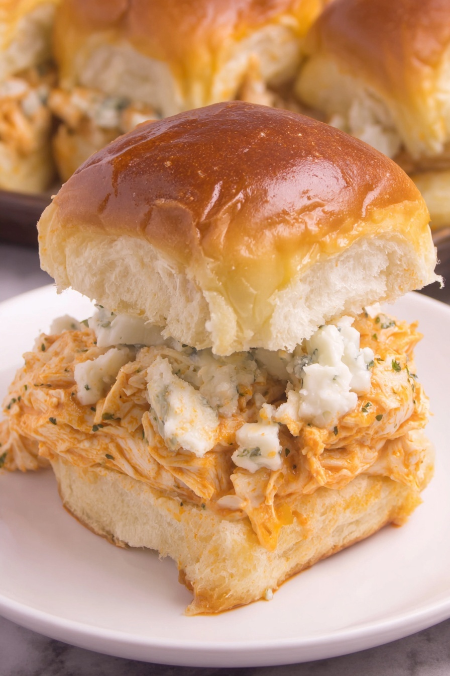 A buffalo chicken slider on a white plate.