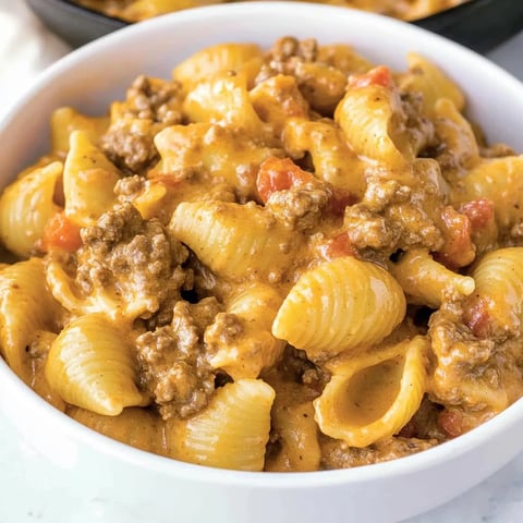 A bowl of pasta with meat and cheese.
