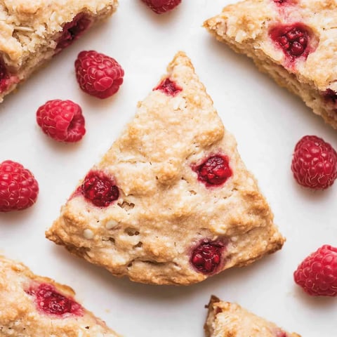 A triangle shaped piece of raspberry almond scone.