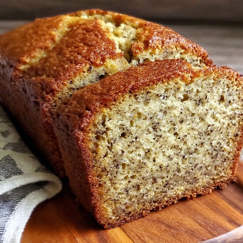 A slice of banana bread on a wooden cutting board.